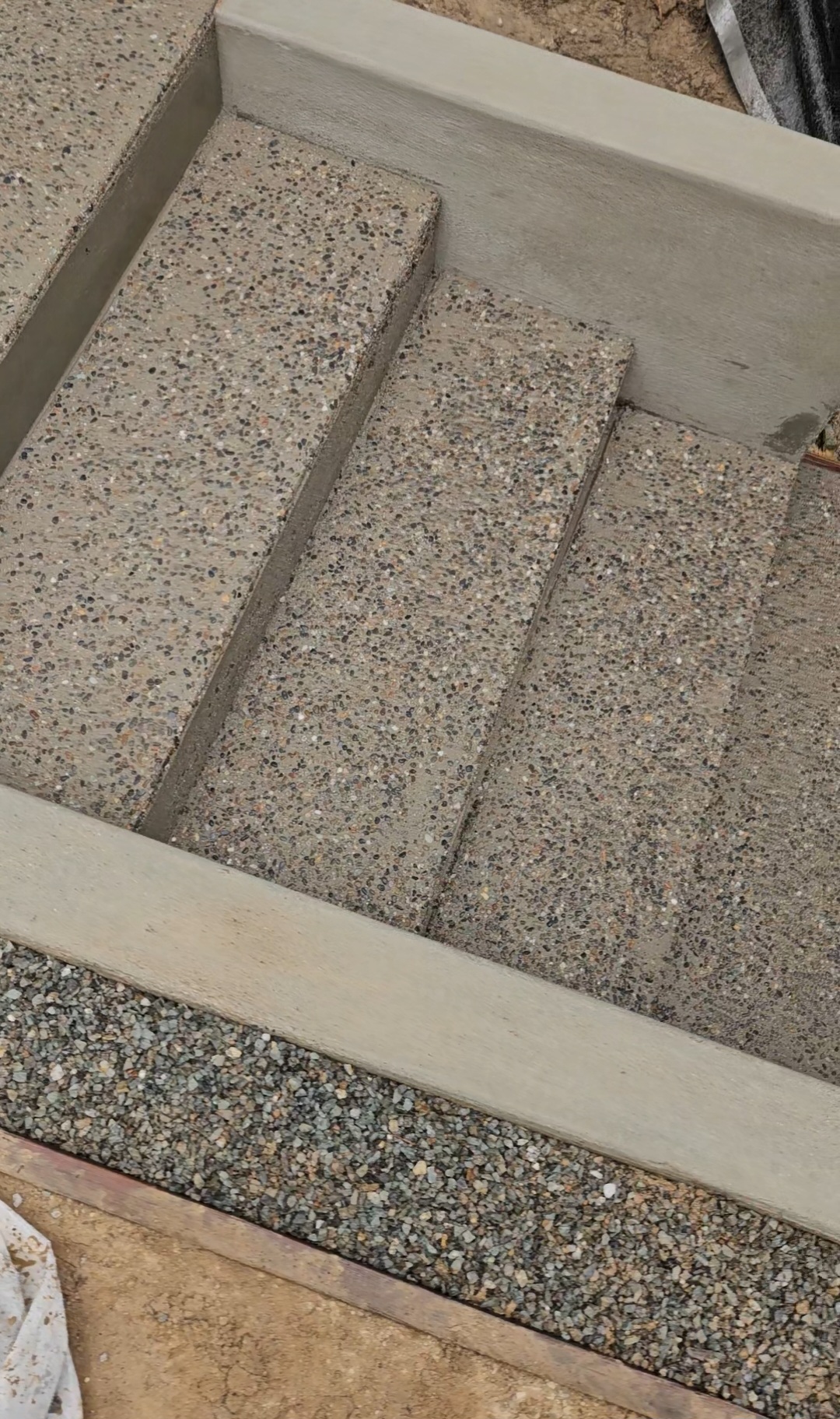 Close-up of finished exposed-aggregate concrete stair treads with crisp risers